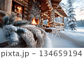 暖炉の光が雪のコテージにクリスマスの温かい雰囲気をもたらす 134659194