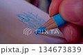 Close-up shot of hand drawing abstract pattern on paper with blue pencil 134673839