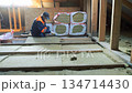 Insulation of a frame house with mineral wool. Cutting, fitting, laying insulation. Construction works. 134714430