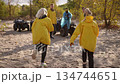 Two friends enjoy playful moments near parked ATV and scattered trees 134744651