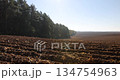 a plowed agricultural field with fertile soil prepared for sowing a new crop of plants, plowed soil in a hilly area prepared in autumn for early spring sowing 134754963