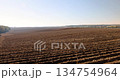 a plowed agricultural field with fertile soil prepared for sowing a new crop of plants, plowed soil in a hilly area prepared in autumn for early spring sowing 134754964