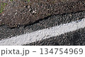the edge of a highway with a thick layer of asphalt on the shoulder, the details of a new paved road with a thick layer of asphalt to ensure the durability of vehicles 134754969
