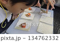 Child preparing pork dumpling with focused concentration, cooking class activity 134762332