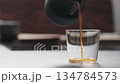 Slow motion pour coffee in tumbler glass on concrete countertop with copy space 134784573