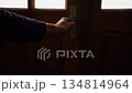Man's left hand opens leaf of wooden door made of natural pine wood with characteristic lines and brightly lit courtyard is displayed. Abstract footage of going out of darkness into bright future, 4k 134814964