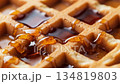 Golden Waffle Delight: A Sweet and Tempting Close-Up of Maple Syrup Pouring Over a Crispy Waffle 134819803