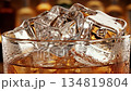 Close-up of a Refreshing Whiskey and Ice Drink in a Glass with a Warm Backdrop 134819804