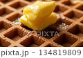 Step-by-step demonstration: adding butter to a fresh waffle for breakfast 134819809