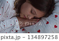 A 10-year-old girl sleeps sweetly in heart-shaped pajamas. High quality 4k footage 134897258