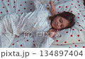 An 11 year old girl wakes up in the morning in her bed wearing heart-shaped pajamas and stretches. High quality 4k footage 134897404