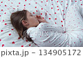 A 10-year-old girl sleeps sweetly in heart-shaped pajamas. High quality 4k footage 134905172