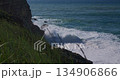 Powerful Ocean Waves Crashing Against a Rocky Coastline on a Sunny Day 134906866