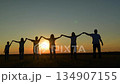 standing strong together under a warm summer sky, joined hands show support, boy strides confidently as the girl keeps pace beside a parent., open field harmony: linked hands at sunset, teamwork 134907155