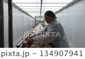 Worker in food processing facility carefully arranging chicken portions on conveyor belt, showcasing meticulous attention, camera pans across scene 134907941
