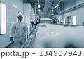Worker in protective gear walks alongside a bubbling production line, showcasing the cleaning process with dynamic camera movement and focus 134907943