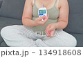 Pregnant woman in her eighth month measuring blood sugar with a portable glucometer. A calm, realistic everyday scene highlighting maternal health, prenatal care, and gestational diabetes management 134918608