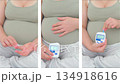 An expectant mother at eight months calmly checks her blood glucose level using a glucometer. The scene captures a mindful moment of self-care and the importance of monitoring gestational diabetes 134918616