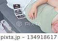 Pregnant woman lying on a couch gently caressing her belly in a calm and cozy home setting. A warm and intimate moment showing maternal love, relaxation, and emotional connection with the unborn baby 134918617