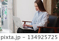 Businesswoman working on laptop while sitting by 134925725