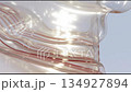 Abstract glossy blurry background, moving shiny waves against the sunlight, modern plastic futuristic backdrop 134927894