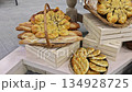 Artisan breads in different shapes are arranged in decorative baskets at local bakery. 134928725
