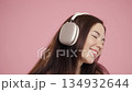 Cheerful Pretty Woman Listening Music, Dances With Wireless Headphones On Pink 134932644