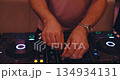 close up of hands and DJ remote control. hands press different buttons play music at night 134934131