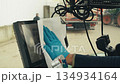worker in protective glove wipes monitor screen in tractor cab with napkin 134934164
