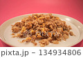 Granola breakfast bowl with fresh milk on a vibrant pink background, slow motion 134934806