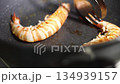 Watch as juicy shrimp sizzle in a hot pan for a delicious seafood delight cooked to perfection 134939157