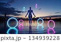 Neon humanoid figure interacts with glowing rings in futuristic cityscape 134939228