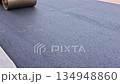 Workers are rolling out fresh asphalt on road surface at construction site during highway maintenance 134948860