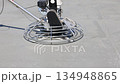 Concrete finishing machine is leveling wet cement at construction site 134948865