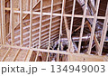 Workers build roof with wooden beams, install ductwork in residential construction site 134949003
