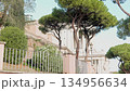Vittoriano Monument In Rome Seen From Garden Path With Trees And Old Walls 134956634