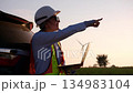 Engineer working with notebook inspector and checking in wind turbine field for power generation 134983104