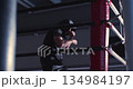 In low light, a man boxer showcases skill and fierce determination during an intense shadow fighting workout. Man boxer during shadow fighting workout in a dark boxing gym. Close-up 4k video. 134984197