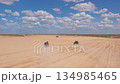 Two buggies racing across the desert, raising dust clouds 134985465