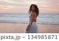 Woman in white dress turning around and smiling at 134985871