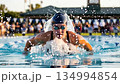 Professional Swimmer Competing in Pool During Sports Competition 134994854