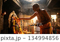 Hindu Priest Performing Ritual at Shrine with Sacred Light 134994856