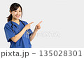 A smiling young female doctor pointing and guiding (white background) 135028301
