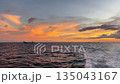 Peaceful ocean sunset with vibrant orange and yellow skies, boat wake 135043167