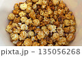 Close up video of caramel popcorn in bucket. Cardboard container is filled with sweet popcorn. After pop, kernels are coated in sweet caramel. Sweet flavored popcorn for trip to movies 135056268