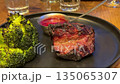 barbecue steak and broccoli Grilled pork steak with broccoli and tomatoes on plate, dark background. 135065307