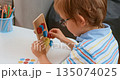 Child Engaging in Creative Play with Colorful Educational Toy 135074025