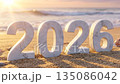 2026 New Year Stone Numbers on Sandy Beach at Sunset with Ocean Waves 135086042