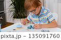Child Engaged in Educational Board Game at Home 135091760