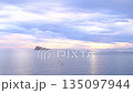 Sunset view over Cala Tio Ximo and Benidorm island. Tranquil winter sea, soft sunset glow, peaceful view of small island near Benidorm. Quiet natural beauty, no people, only sea and sky. 135097944